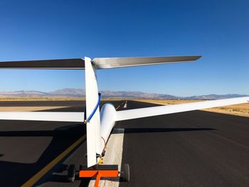 Airplane wing against clear blue sky