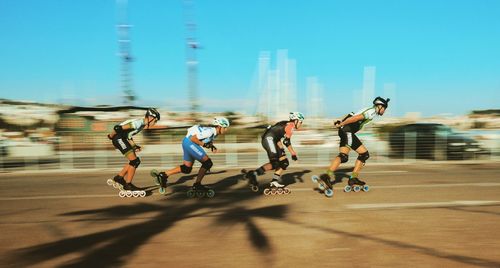 Group of people running on zebra crossing in city