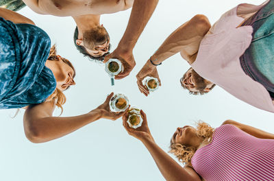 Group of people drinking monito cocktail. bottom up view