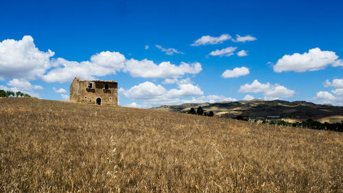 Panoramic view of building on field against sky