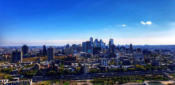 High angle view of buildings in city against blue sky