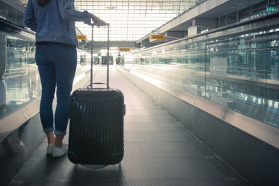Low section of man standing at railroad station
