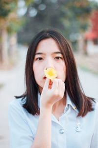 Portrait of young woman holding ice cream