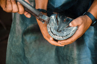 Close-up of people fixing horseshoe