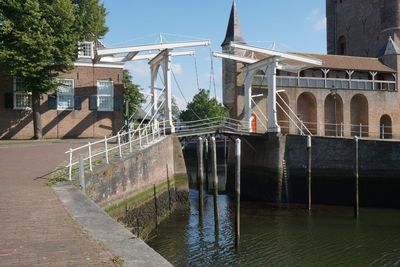 Arch bridge over river against buildings in city