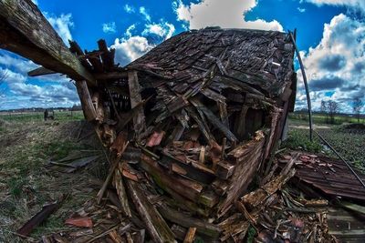 Old ruin on field against cloudy sky