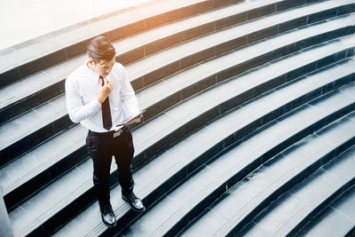 High angle view of businessman using digital tablet on steps