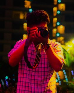 Portrait of young man standing at night