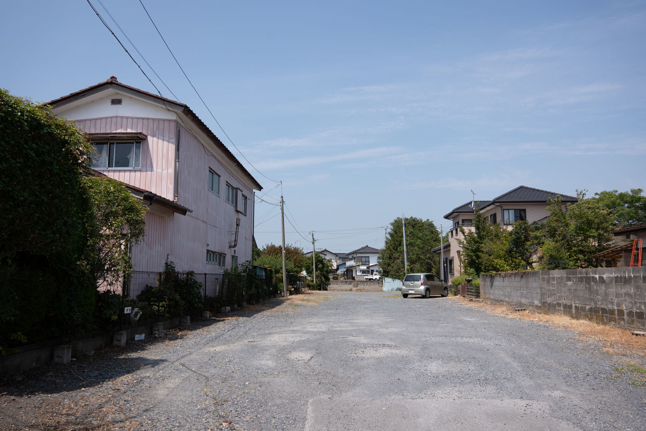 ROAD AMIDST BUILDINGS AGAINST SKY