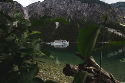 People in boat traveling in mountain lake