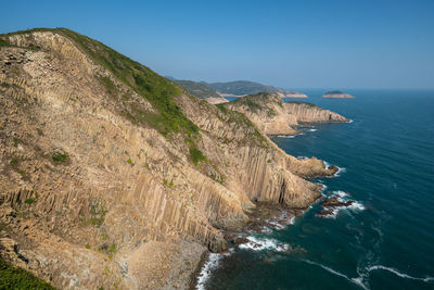 Scenic view of sea and mountains against clear blue sky