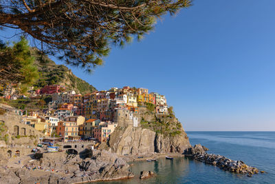 Panoramic view of townscape by sea against clear sky