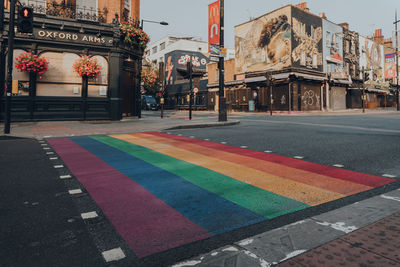 Multi colored flags on street against buildings in city