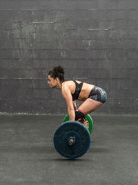 Full length of woman exercising on flooring