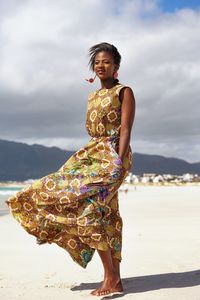 Woman walking at beach against sky