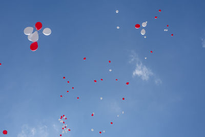 Low angle view of balloons flying against sky