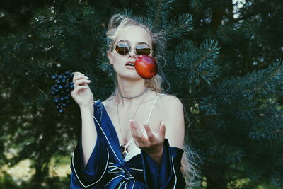 Woman throwing apple against trees