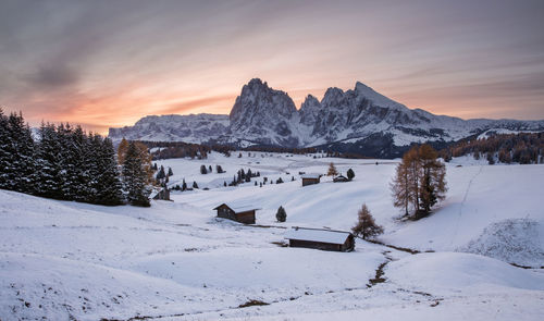 Scenic view of snow covered landscape against sky at sunset