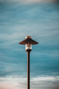 View of bird perching on pole against sky