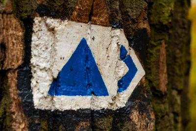 Close-up of arrow sign on wood