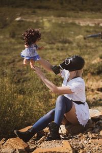 Rear view of girl playing with toy on field