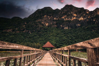 Footbridge amidst mountains against sky