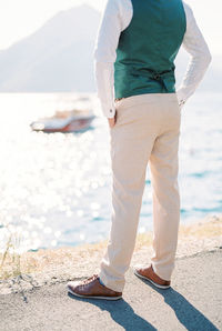 Low section of man standing on beach