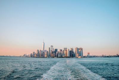 Scenic view of sea by buildings against clear sky