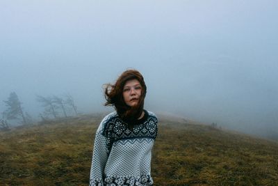 Portrait of a young woman standing on ground