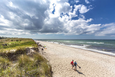 People at beach against sky