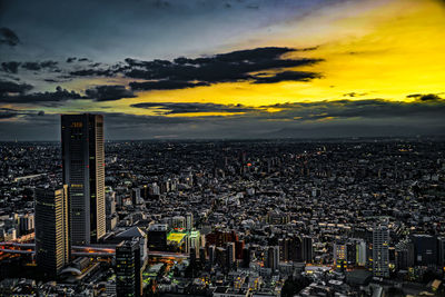 High angle view of city against cloudy sky during sunset