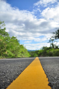 Surface level of empty road against trees