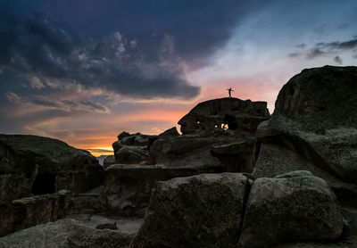 Rock formation by sea against sky during sunset