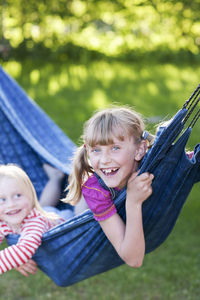 Two sisters laughing in hammock