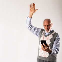 Low angle view of man using smart phone against white background