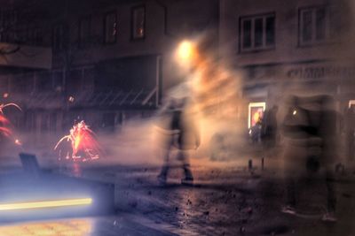 Illuminated city street during rainy season at night