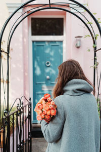 Portrait of woman holding red flowers