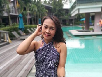 Portrait of woman in swimwear standing at poolside