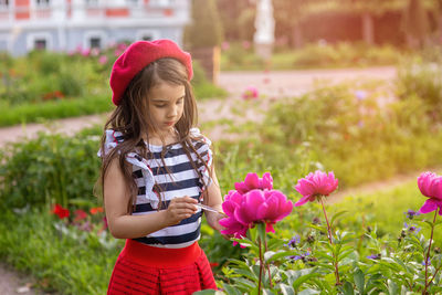 Girl in the park next to peonies