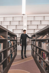 Full length of a young man standing in book