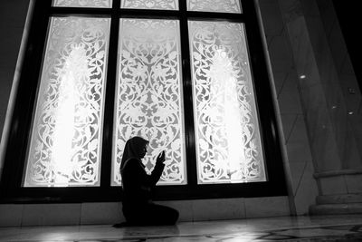 Woman sitting by window