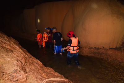 Rear view of people walking on rock