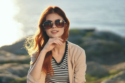 Portrait of young woman wearing sunglasses standing outdoors