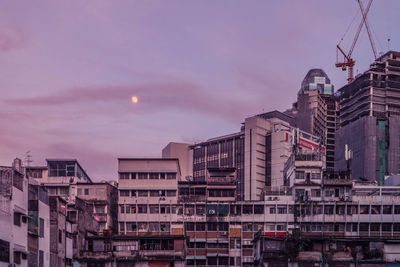 Buildings in city against sky at sunset