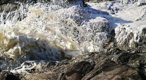 Water splashing on rocks in sea