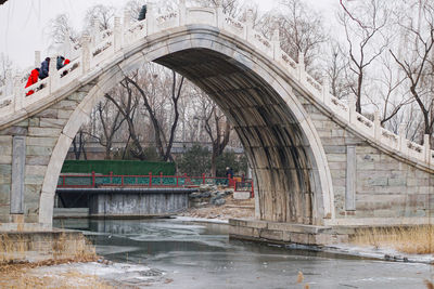 Arch bridge over river during rainy season