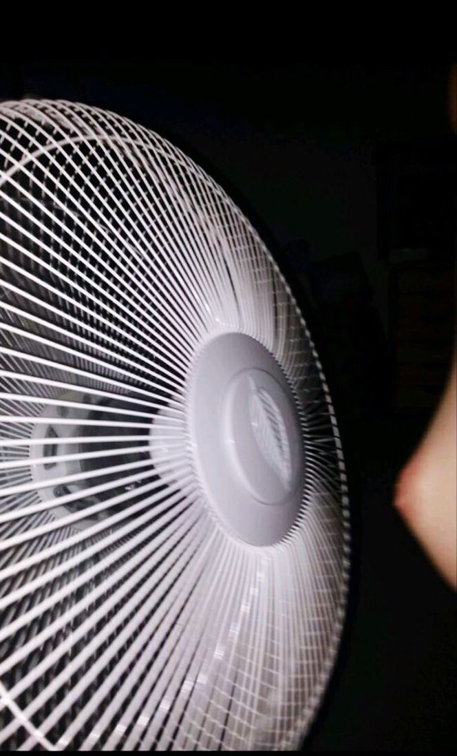 CLOSE-UP OF HUMAN HAND ON ELECTRIC FAN