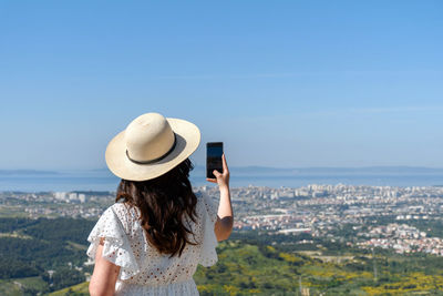 Rear view of woman taking photos of cityscape of split in croatia