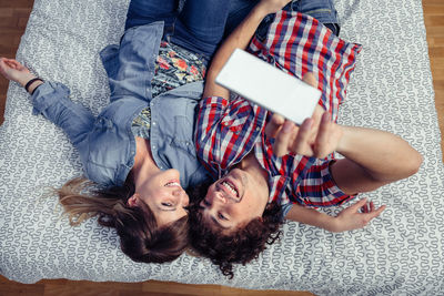 High angle view of woman using mobile phone while sitting on sofa