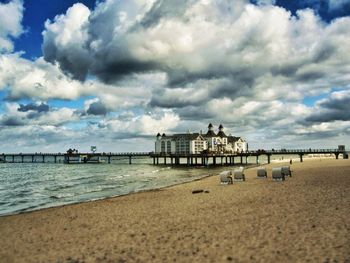 Pier on sea against cloudy sky